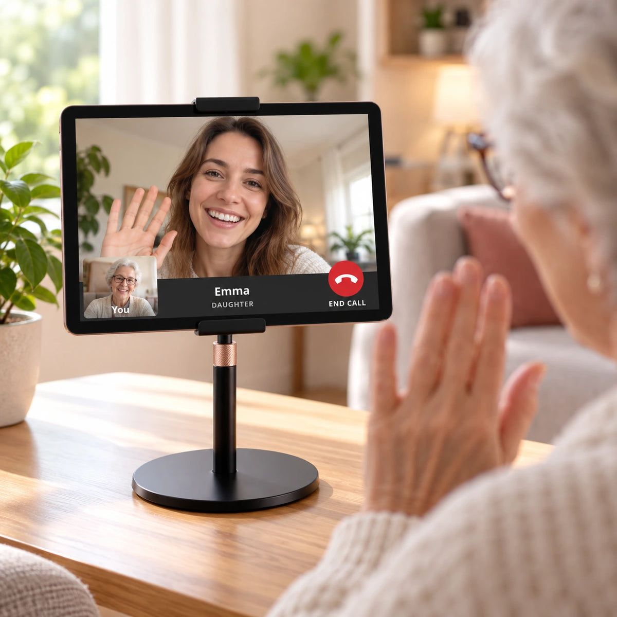 Older woman testing a Heedy video call with her daughter using a tablet mounted on the adjustable tabletop stand.
